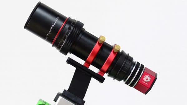 Player One Ceres-C camera attached to a mini guide scope with black and red design mounted on a bracket against a white background.
