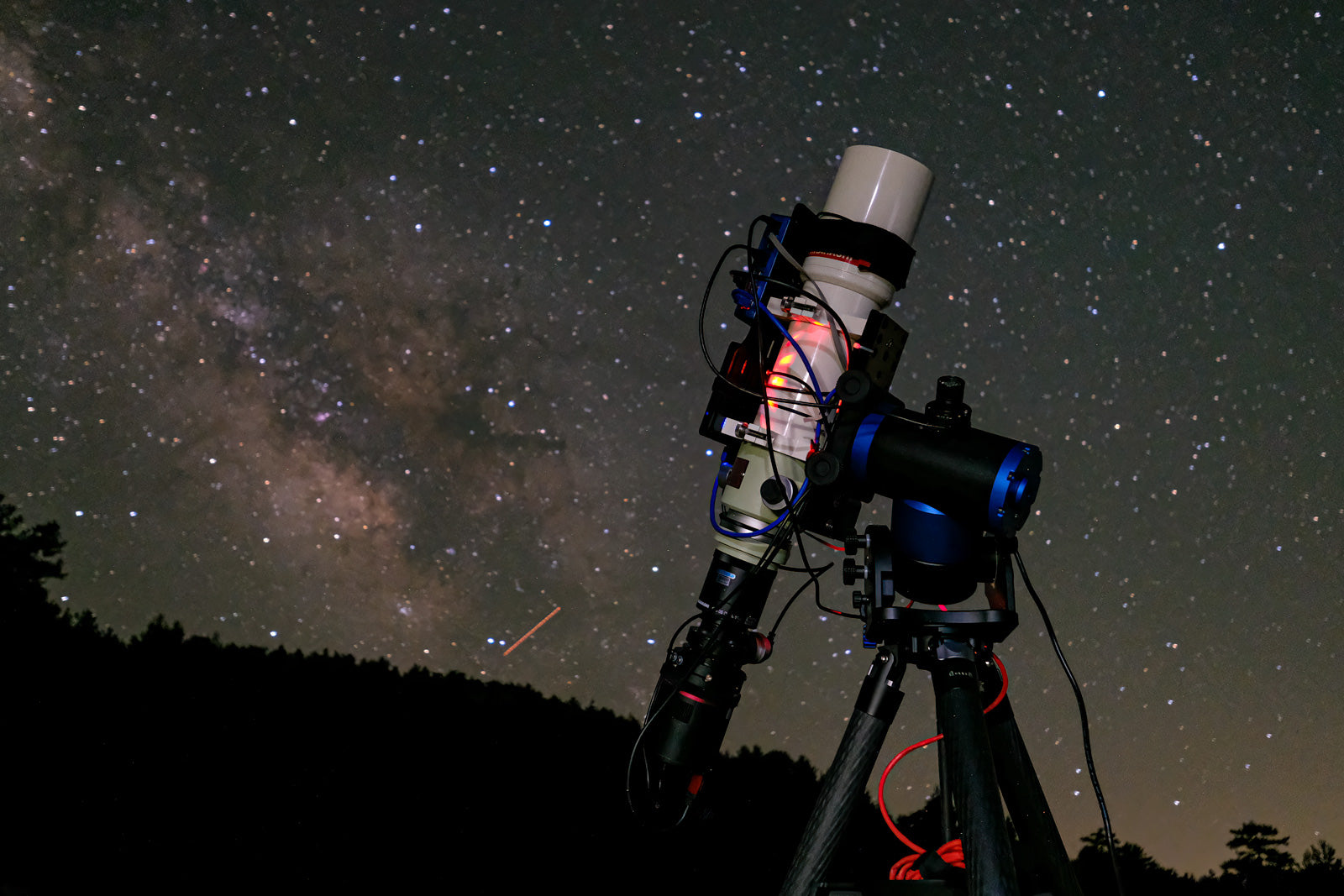 Pegasus NYX-101 harmonic mount with refractor telescope set up under the night sky, capturing the Milky Way in a dark-sky location.